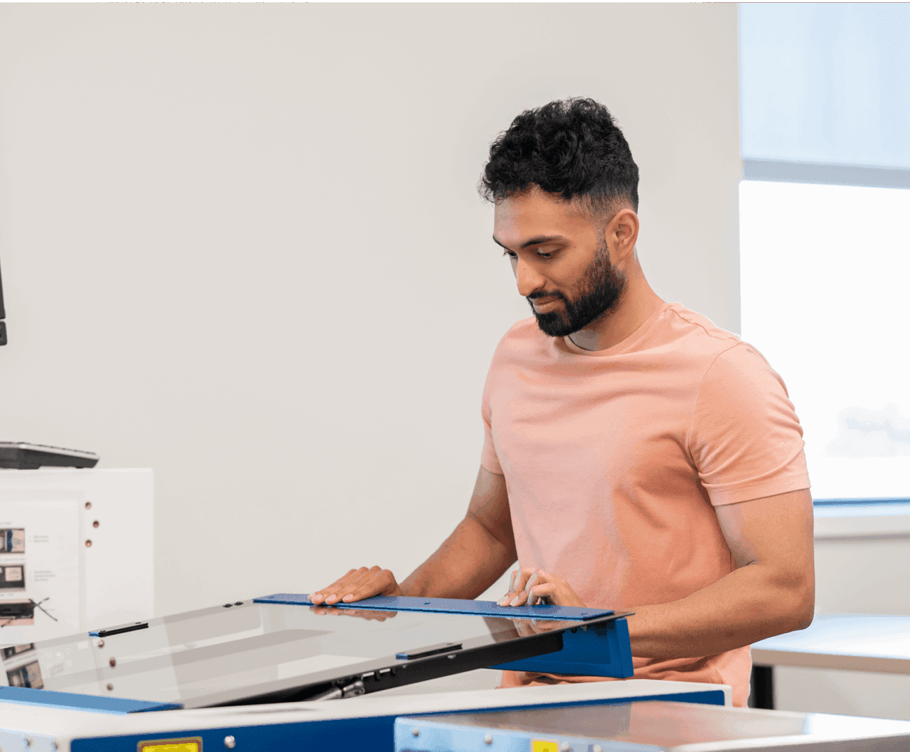 Person in pink shirt at copier