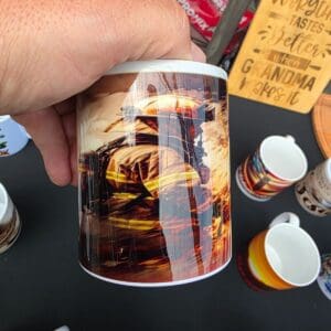 Hand holding a colorful mug