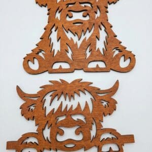 Wooden Highland cow-themed cutout decorations.